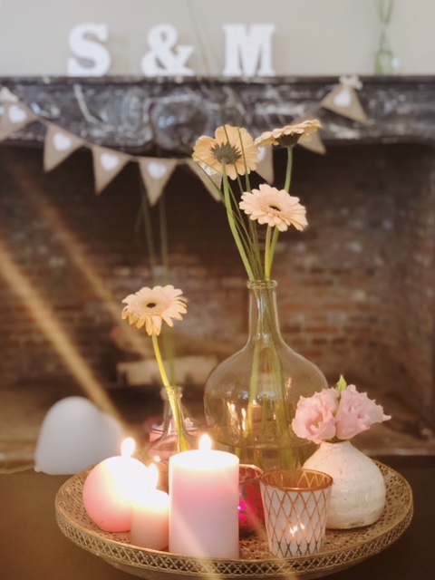 Vazen met bloemen en kaarsen met roze tinten